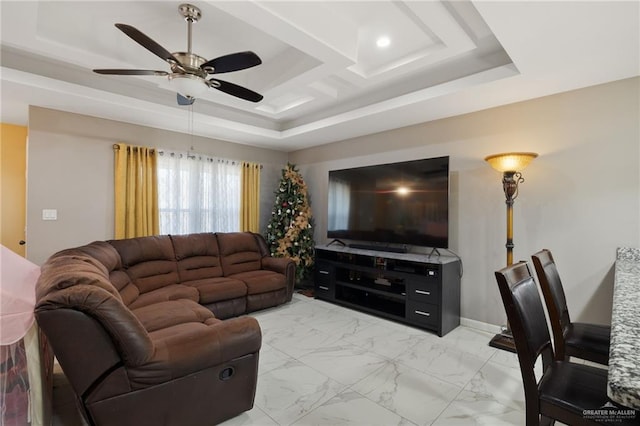 living room with a raised ceiling and ceiling fan