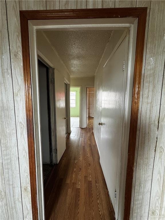 hall with dark hardwood / wood-style floors and a textured ceiling