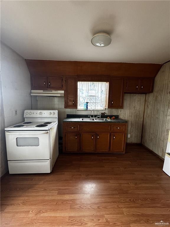 kitchen with sink, electric range, and light hardwood / wood-style flooring