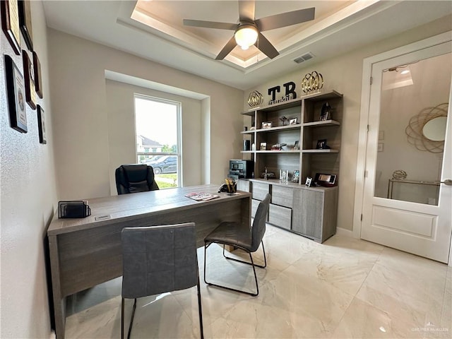 office with a raised ceiling and ceiling fan