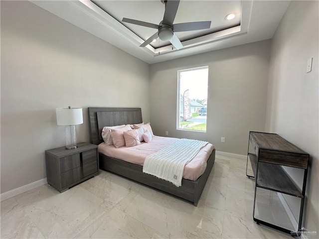 bedroom featuring ceiling fan and a raised ceiling