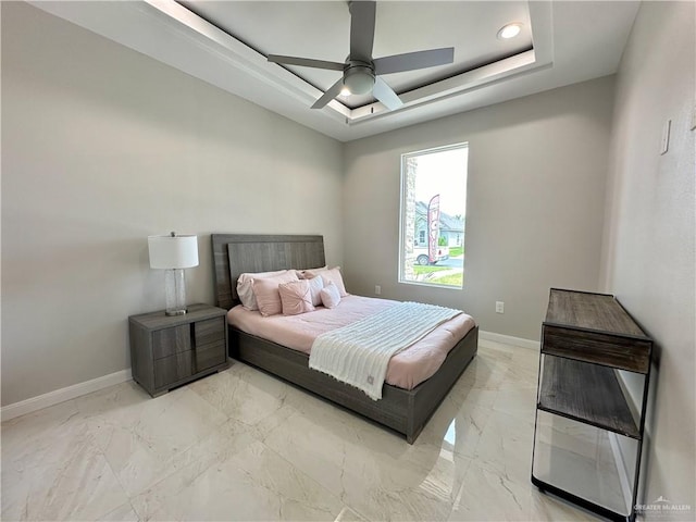 bedroom with a tray ceiling and ceiling fan