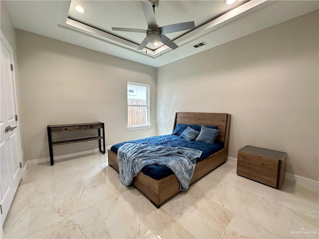 bedroom with ceiling fan and a raised ceiling