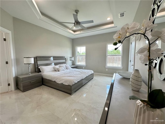 bedroom with a raised ceiling and ceiling fan