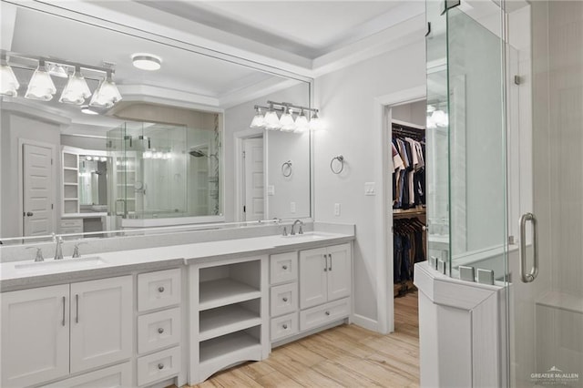 bathroom featuring crown molding, a shower with door, vanity, and hardwood / wood-style flooring