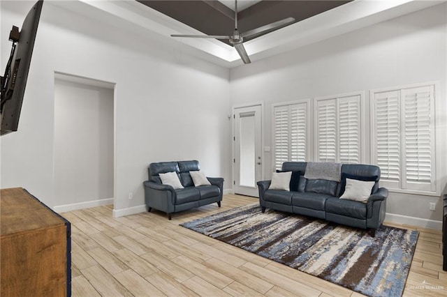 living room with ceiling fan, plenty of natural light, and light wood-type flooring