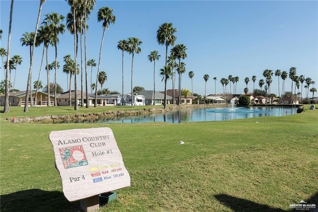 view of home's community with a water view and a lawn