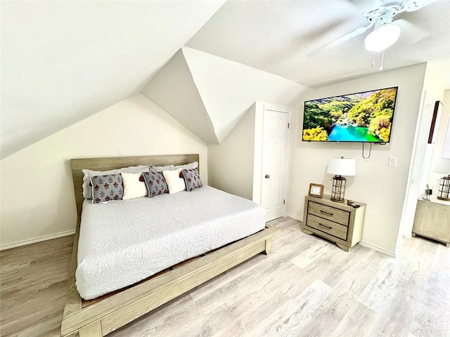 bedroom featuring baseboards, vaulted ceiling, and wood finished floors