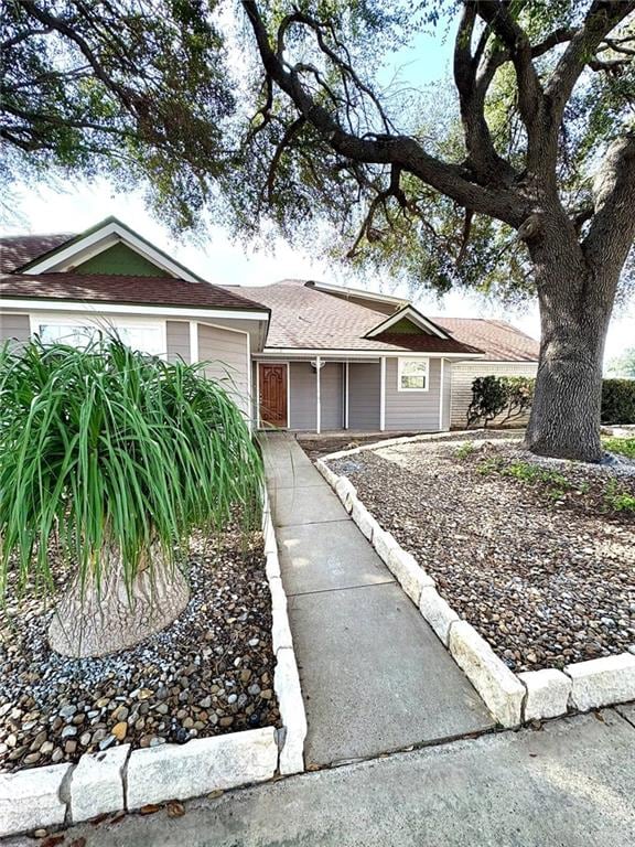 single story home with roof with shingles and an attached garage