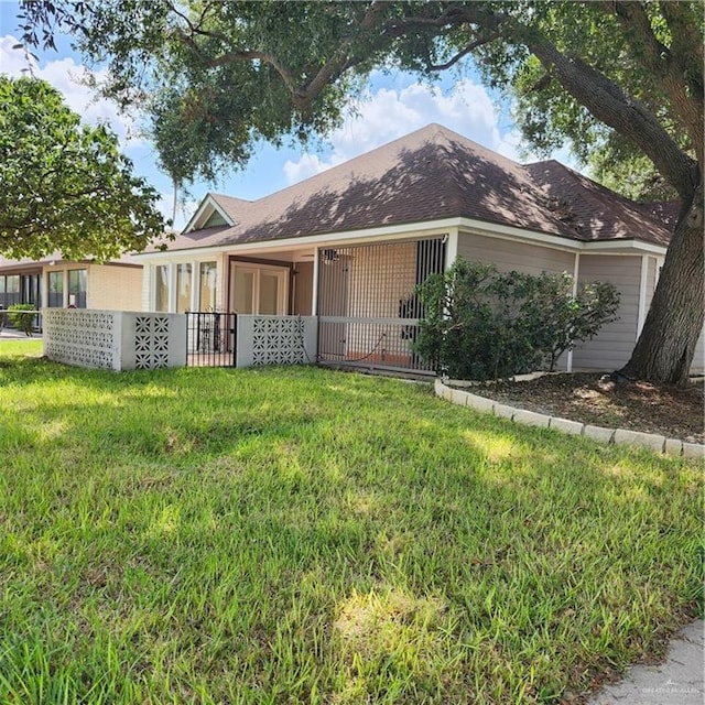 single story home featuring a front yard and a shingled roof