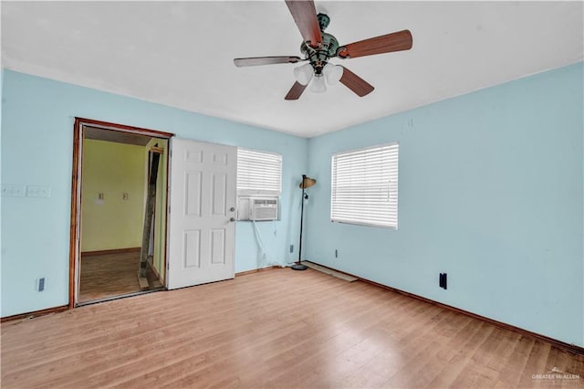 unfurnished bedroom with ceiling fan, light wood-type flooring, cooling unit, and baseboards