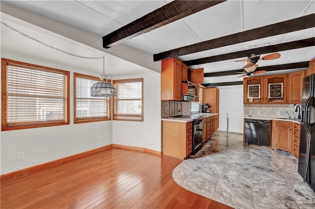 kitchen featuring brown cabinetry, light countertops, and black appliances