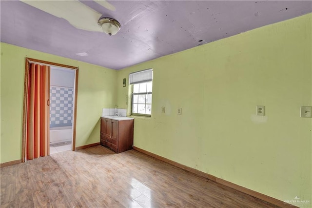 spare room featuring light wood finished floors and baseboards