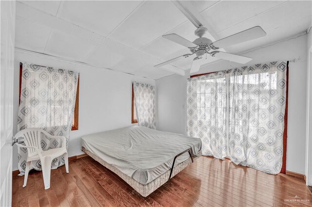 bedroom featuring baseboards, a ceiling fan, and wood finished floors