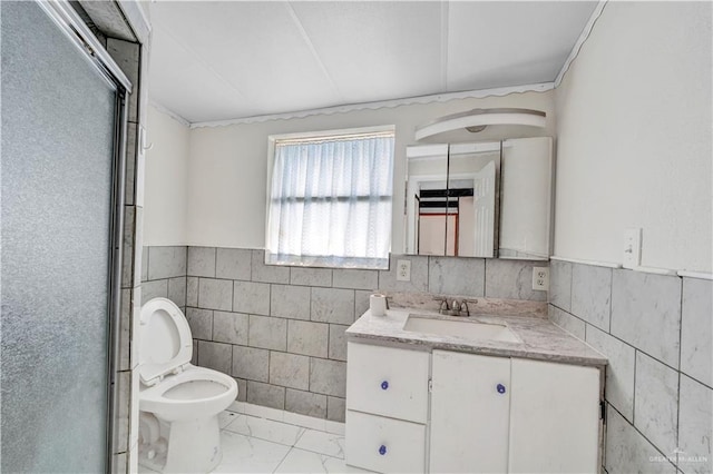 bathroom featuring toilet, vanity, tile walls, marble finish floor, and wainscoting