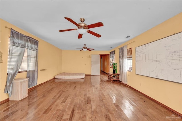 interior space with light wood-type flooring, visible vents, and baseboards