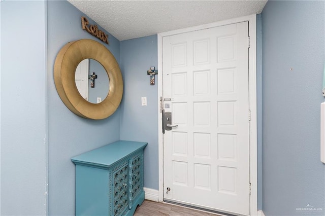 3000 Gulf Blvd Unit 701, South Padre Island, TX 78597 - doorway to outside with a textured ceiling and wood finished floors