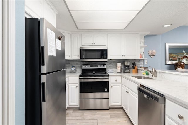 3000 Gulf Blvd Unit 701, South Padre Island, TX 78597 - kitchen with appliances with stainless steel finishes, open shelves, backsplash, white cabinetry, and light countertops
