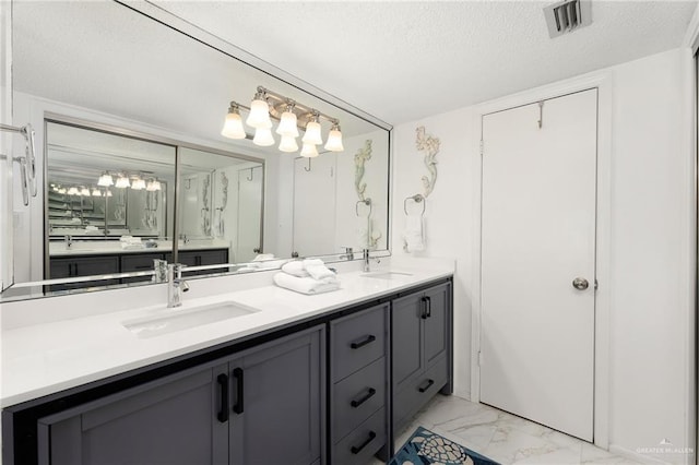 3000 Gulf Blvd Unit 701, South Padre Island, TX 78597 - full bath with marble look tiles, double vanity, and a textured ceiling