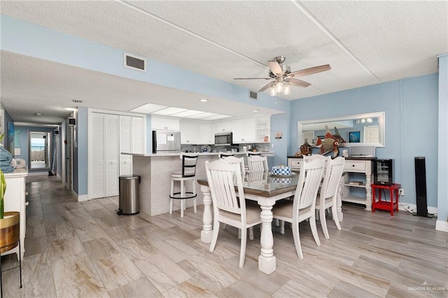 3000 Gulf Blvd Unit 701, South Padre Island, TX 78597 - dining space with a ceiling fan, a textured ceiling, and light wood finished floors