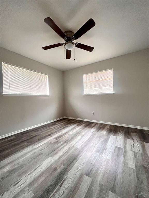 empty room with hardwood / wood-style floors and ceiling fan