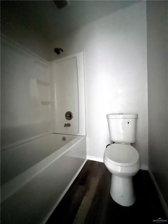 bathroom featuring bathing tub / shower combination, toilet, and hardwood / wood-style flooring