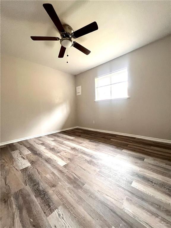 empty room with hardwood / wood-style floors and ceiling fan