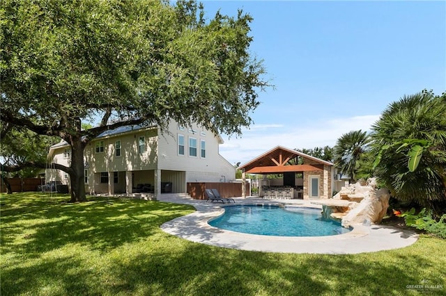 view of swimming pool featuring a lawn, exterior bar, a hot tub, and a patio