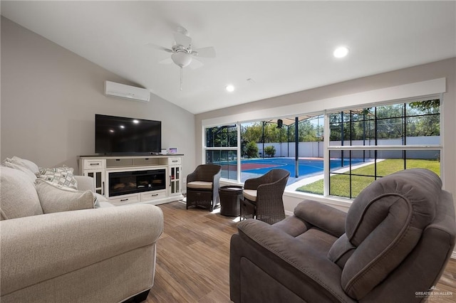 living room with plenty of natural light, ceiling fan, a wall unit AC, and light hardwood / wood-style flooring