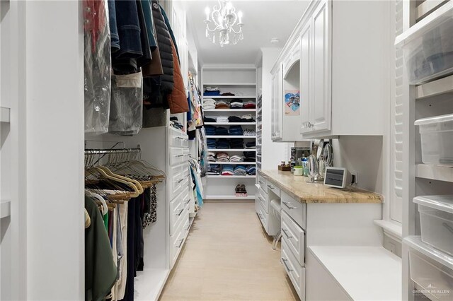 walk in closet featuring an inviting chandelier