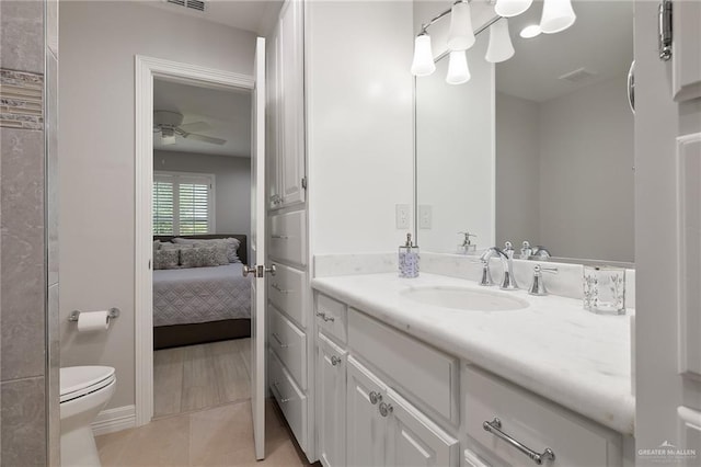 bathroom with tile patterned floors, ceiling fan, toilet, and vanity