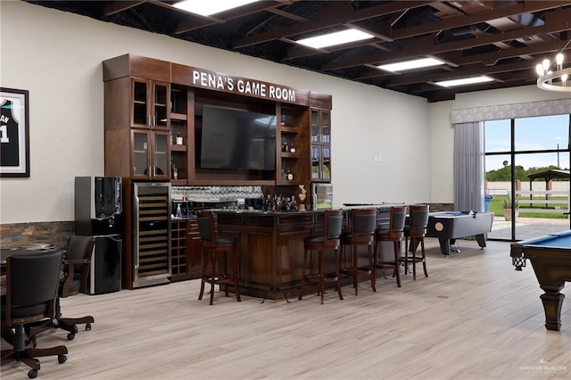 bar featuring wine cooler, dark brown cabinetry, light hardwood / wood-style floors, and billiards