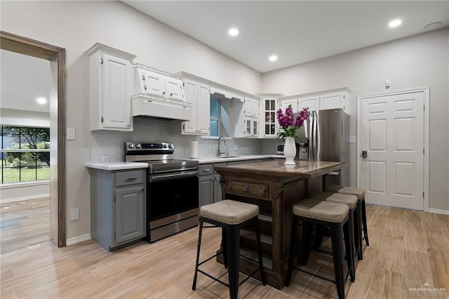 kitchen with gray cabinetry, white cabinetry, sink, stainless steel appliances, and light hardwood / wood-style floors