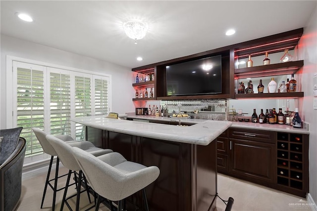 bar with light stone countertops and a wealth of natural light