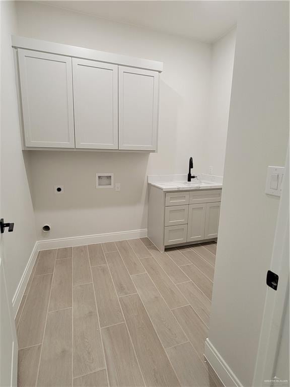 laundry room featuring hookup for an electric dryer, wood finish floors, hookup for a washing machine, baseboards, and cabinet space