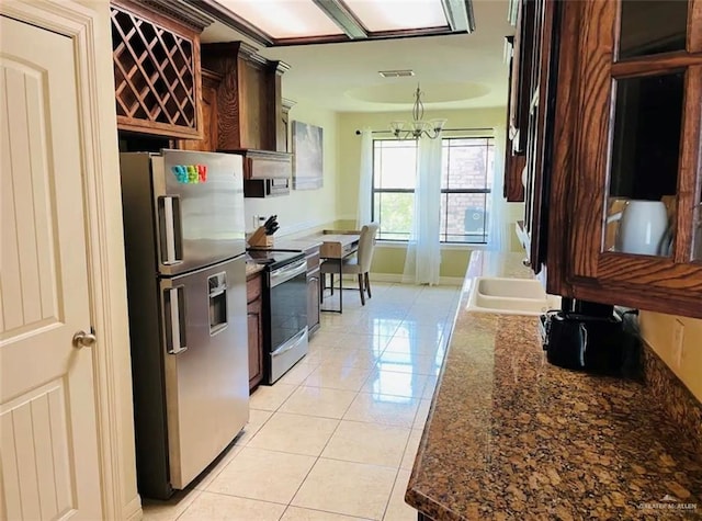 kitchen with sink, stainless steel appliances, a chandelier, dark brown cabinets, and light tile patterned floors