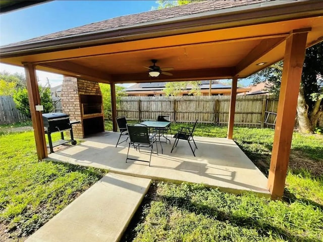 view of patio / terrace featuring grilling area, ceiling fan, and a brick fireplace