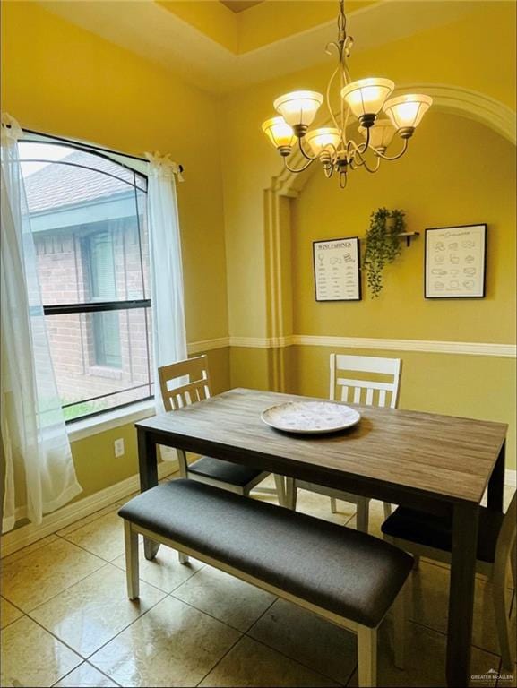 tiled dining area featuring a notable chandelier