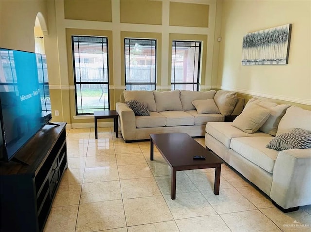 living room featuring a towering ceiling and light tile patterned flooring