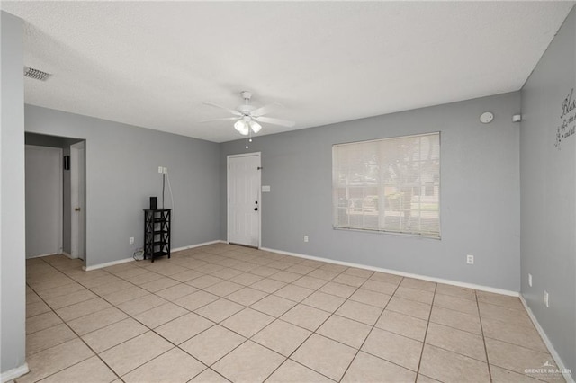 tiled spare room with ceiling fan