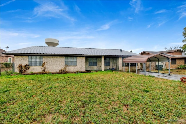 single story home featuring brick siding, metal roof, a front lawn, and a detached carport