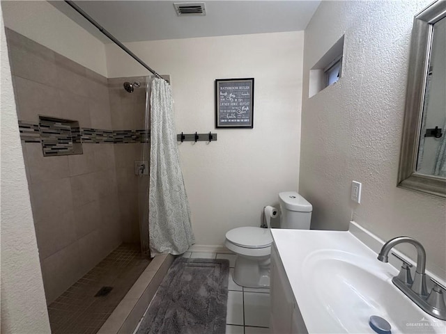 bathroom featuring toilet, vanity, tile patterned floors, and walk in shower