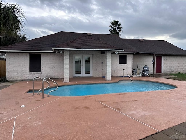 view of swimming pool with french doors and a patio