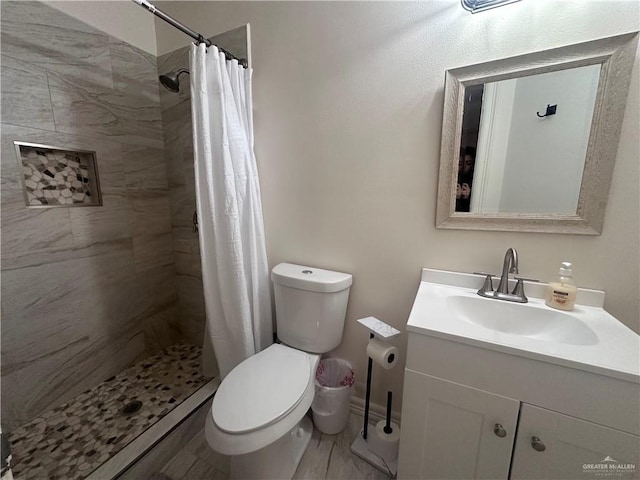 bathroom featuring vanity, curtained shower, and toilet