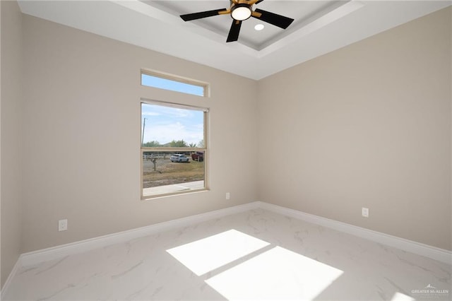 unfurnished room featuring ceiling fan and a tray ceiling