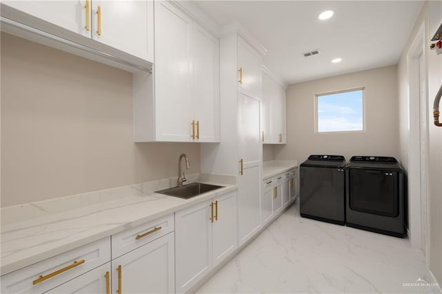 washroom featuring cabinets, independent washer and dryer, and sink