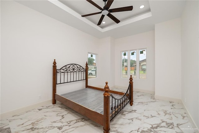 bedroom featuring a tray ceiling and ceiling fan