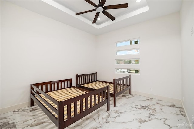 bedroom featuring a raised ceiling and ceiling fan