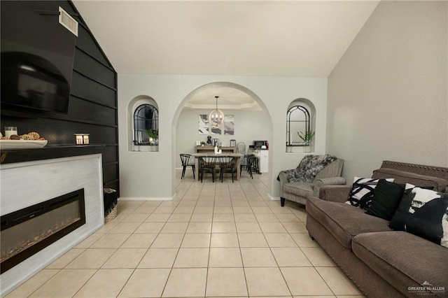 living room with lofted ceiling, light tile patterned floors, and a notable chandelier