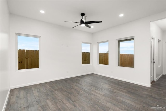 spare room with ceiling fan, a healthy amount of sunlight, and dark hardwood / wood-style flooring